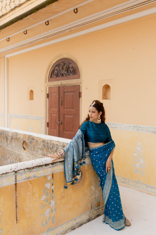 Raw silk blouse with golden ace paired with elegant teal saree to enhance ethnic look