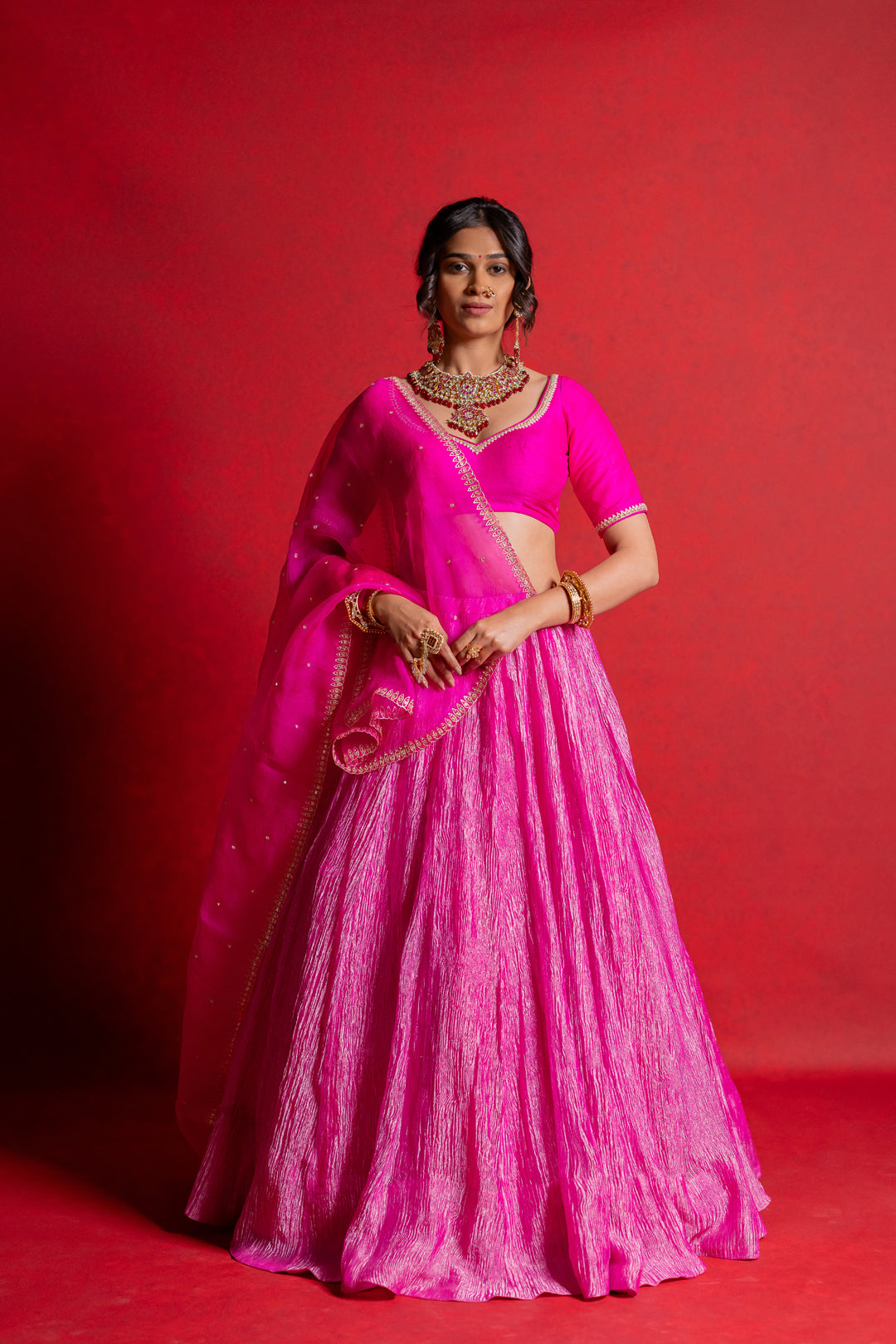 A pink lehenga set with a hand-embroidered blouse and a sheer dupatta.