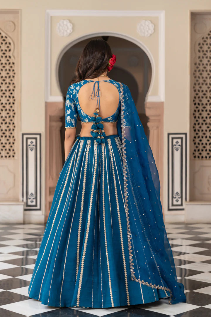 Woman wearing a blue traditional outfit with intricate designs