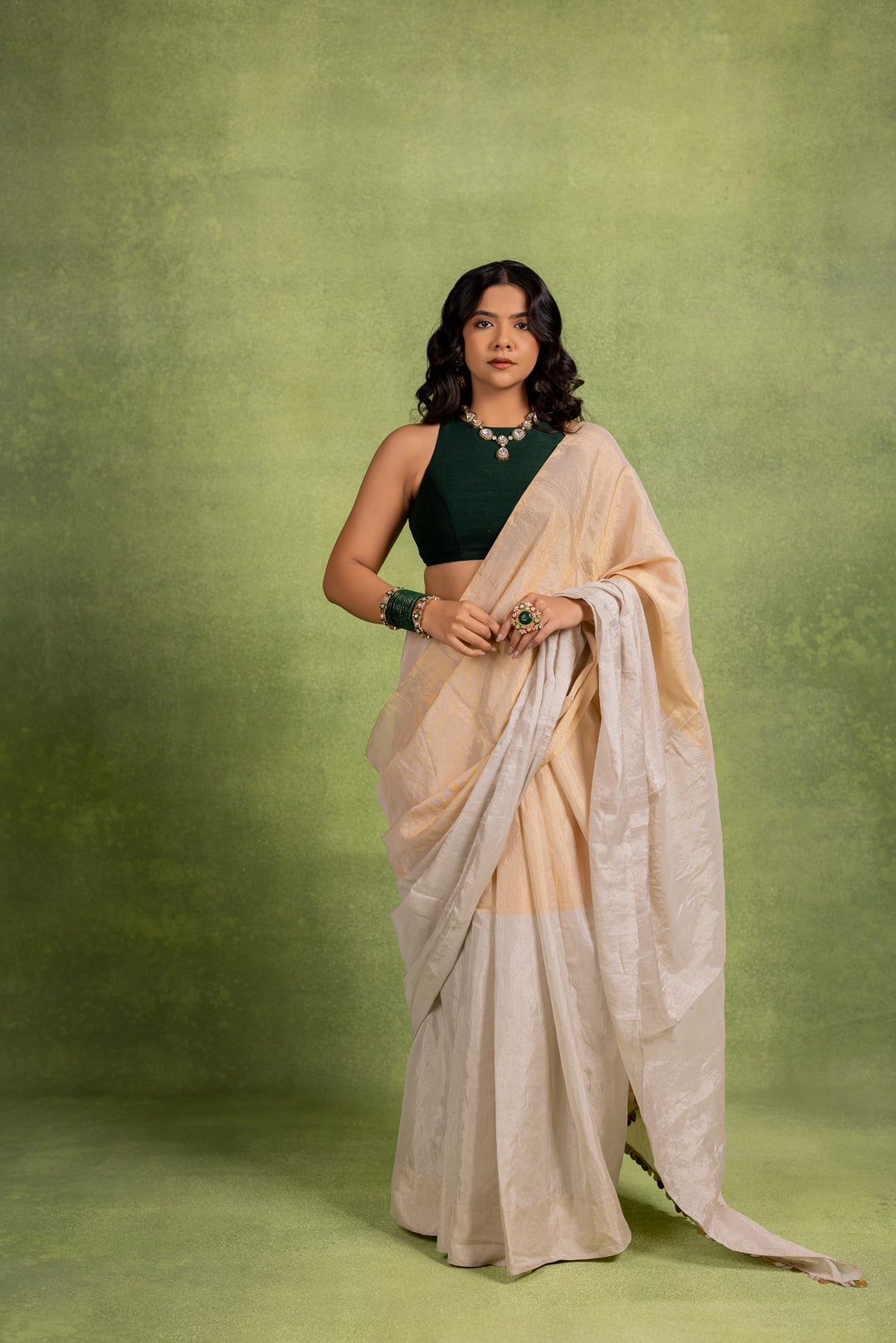A beige and white tissue saree with a coin-trimmed border